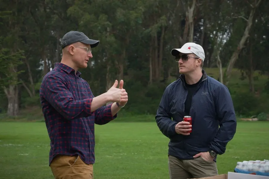 Two teammates talking at an offsite in the park