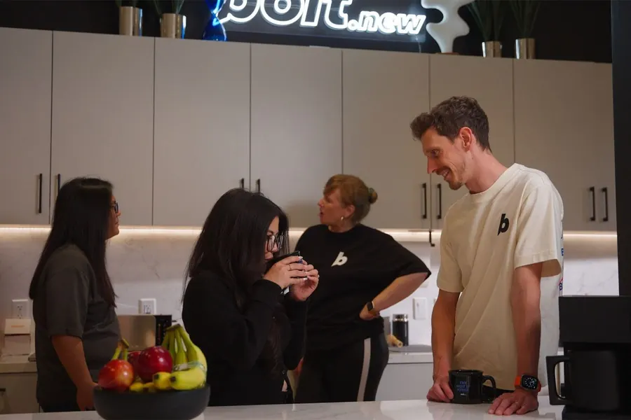 Teammates catching up over coffee in the office kitchen