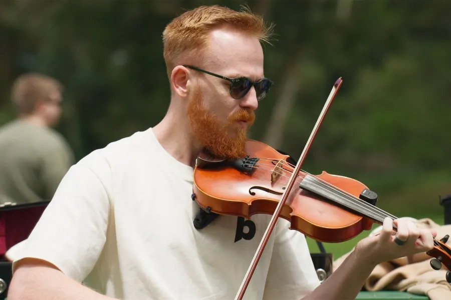 A teammate playing violin at an offsite
